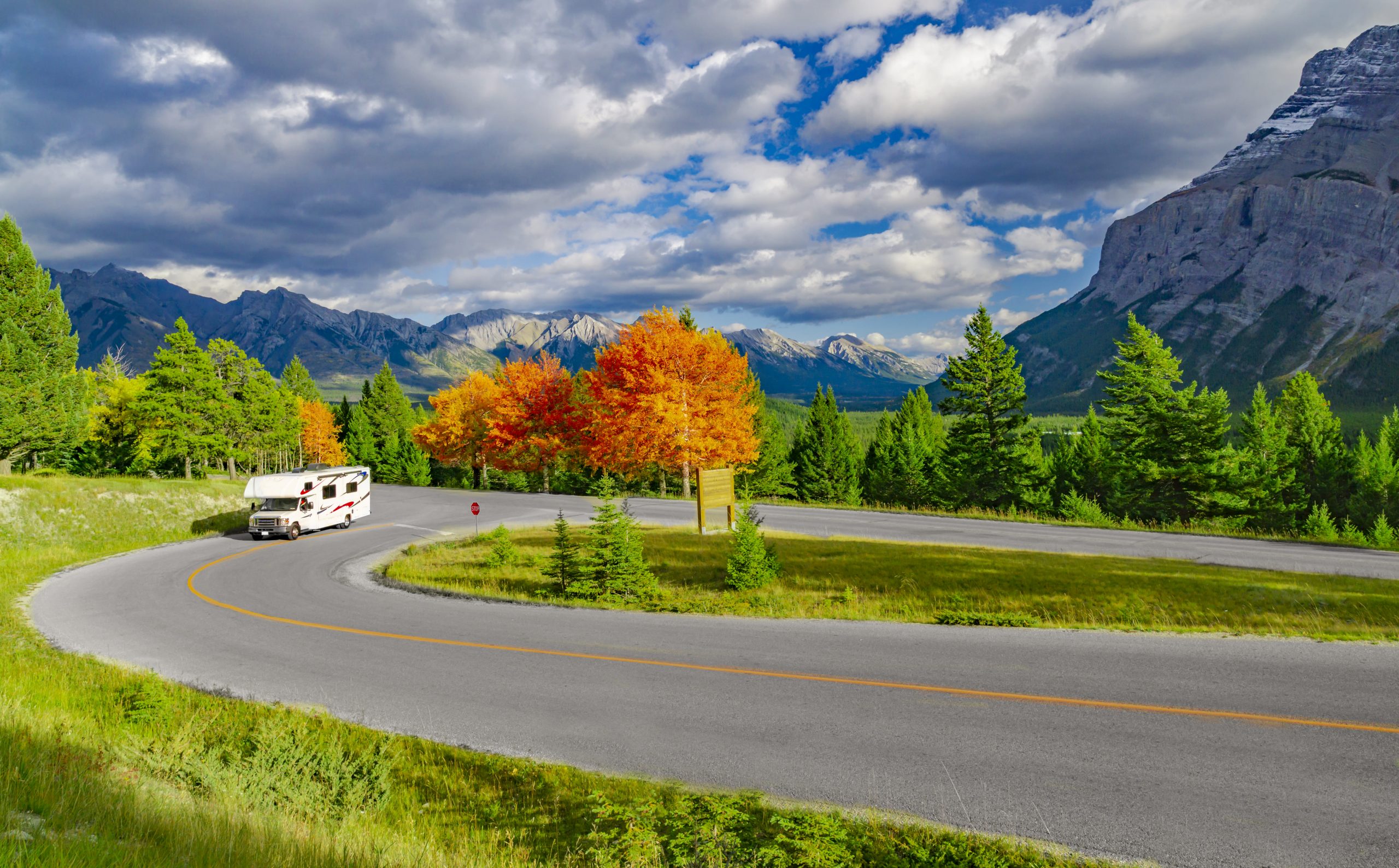 RV on a winding road with trees in background