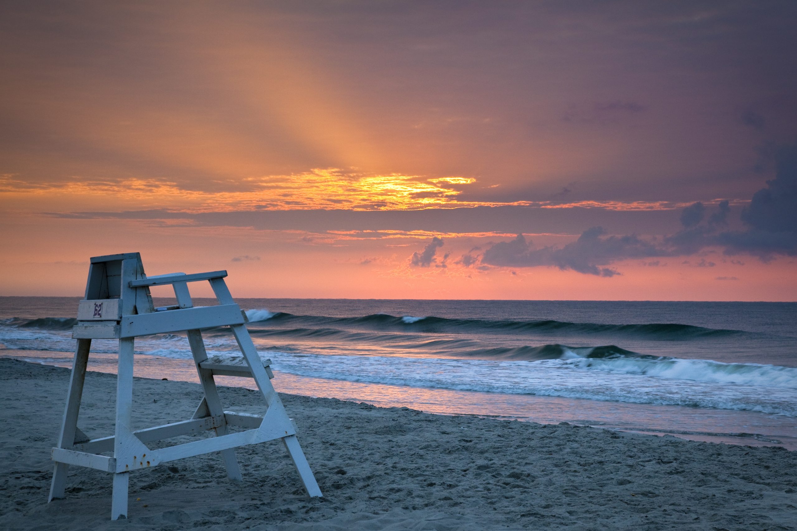 A beautiful sunrise over Myrtle beach with a lifeguard chair on the shore in South Carolina
